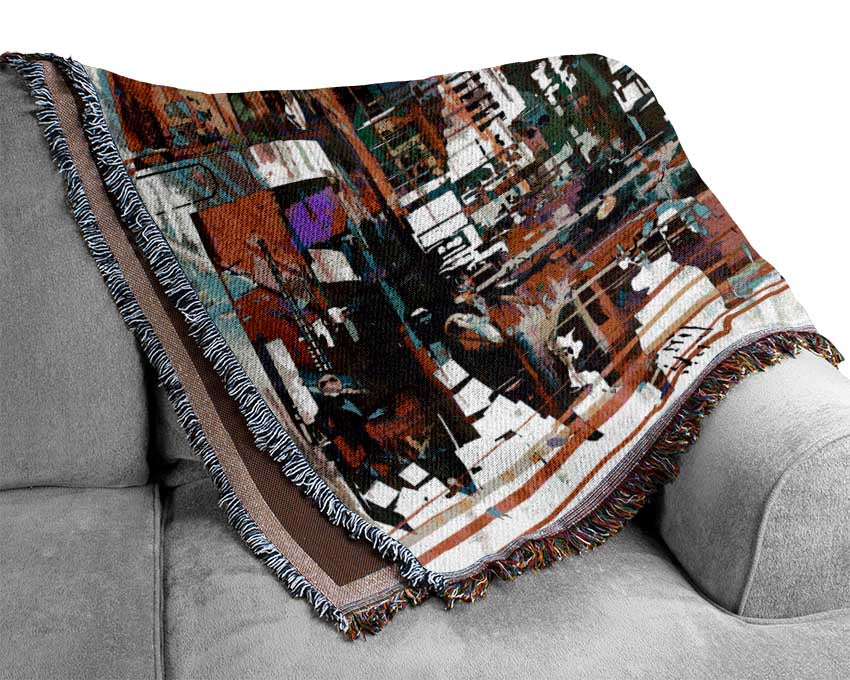 A luxurious Abstract City Art throw blanket made from 100% cotton, featuring a modern abstract design in vibrant colors, draped elegantly over a couch.