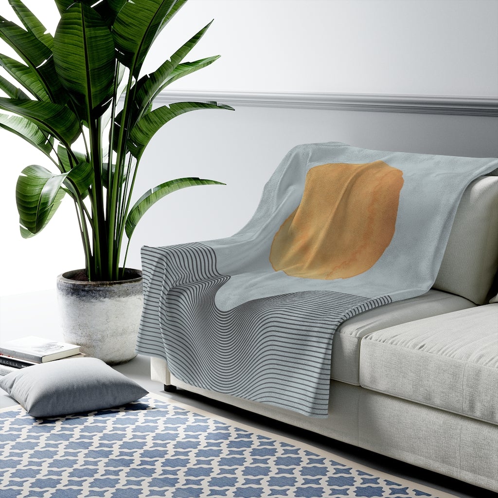 A cozy blue plush throw featuring abstract sun art design, available in three sizes, perfect for home decor.