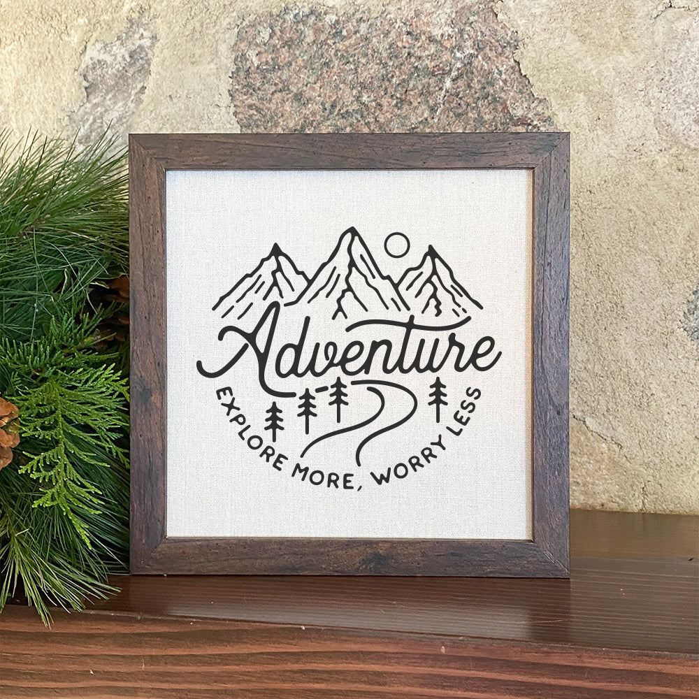 Adventure-Explore More framed sign with a wood frame and linen-look background, perfect for home decor.