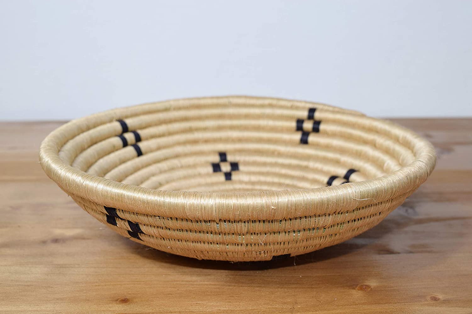 A beautifully handwoven African sisal basket from Rwanda, showcasing intricate patterns and vibrant colors, perfect for home decor or storage.