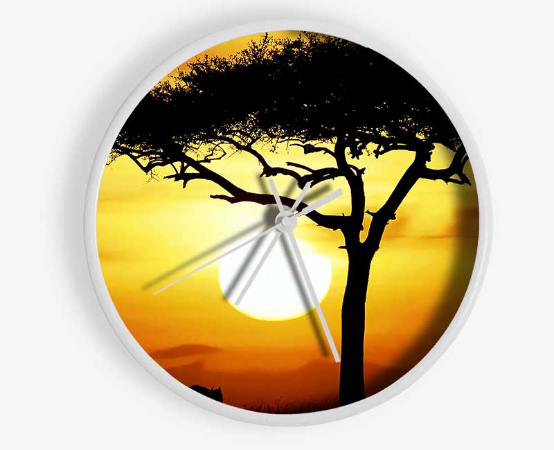 A stylish African Safari Tree clock made from natural bamboo, featuring a round face and clear Plexiglas lens, displayed in sunlight.
