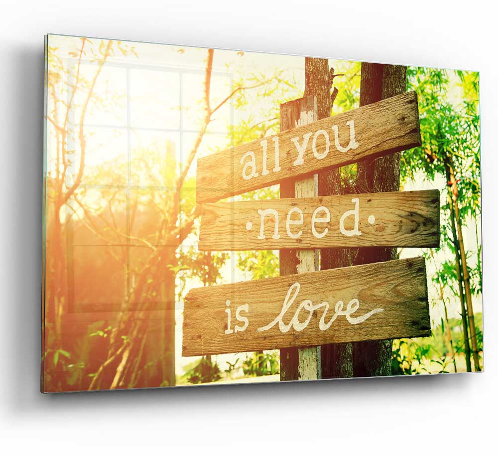 A modern glass print featuring the quote 'All You Need Is Love' in elegant typography, perfect for home decor.