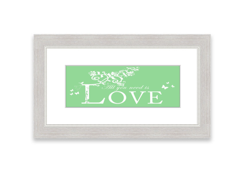 Framed print of 'All You Need Is Love' in green, showcasing vibrant colors and a heartfelt message, ready to hang.