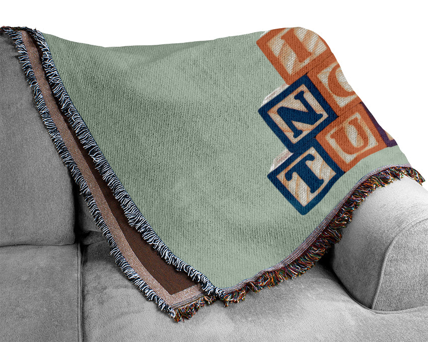 A soft and stylish baby blanket in blue featuring playful alphabet blocks design, made from 100% cotton for comfort and breathability.