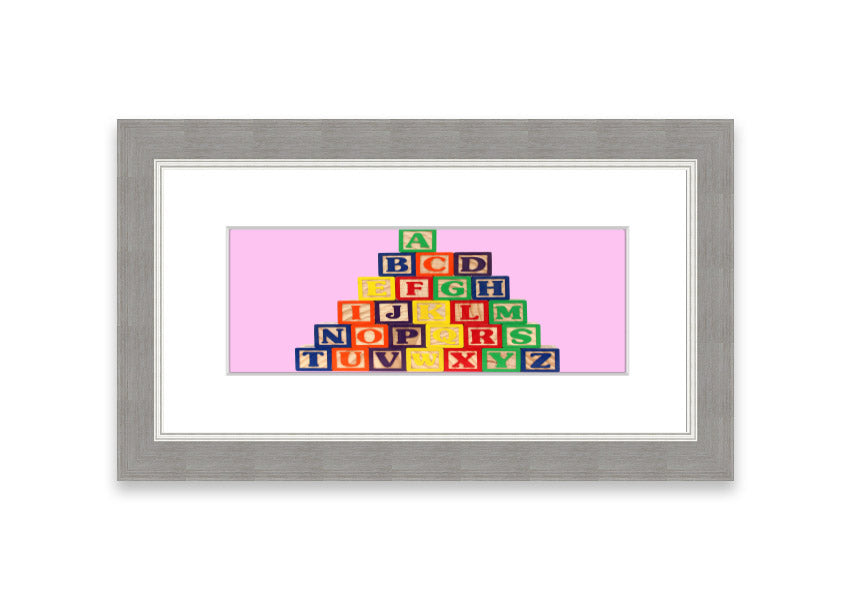 A charming pink framed print featuring colorful alphabet blocks, perfect for children's rooms.