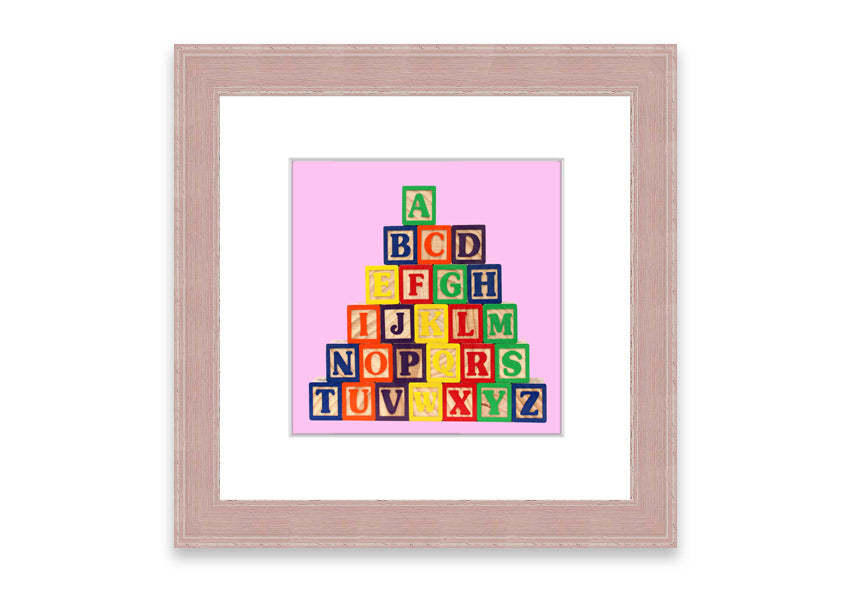 A charming pink framed print featuring colorful alphabet blocks, perfect for children's rooms.