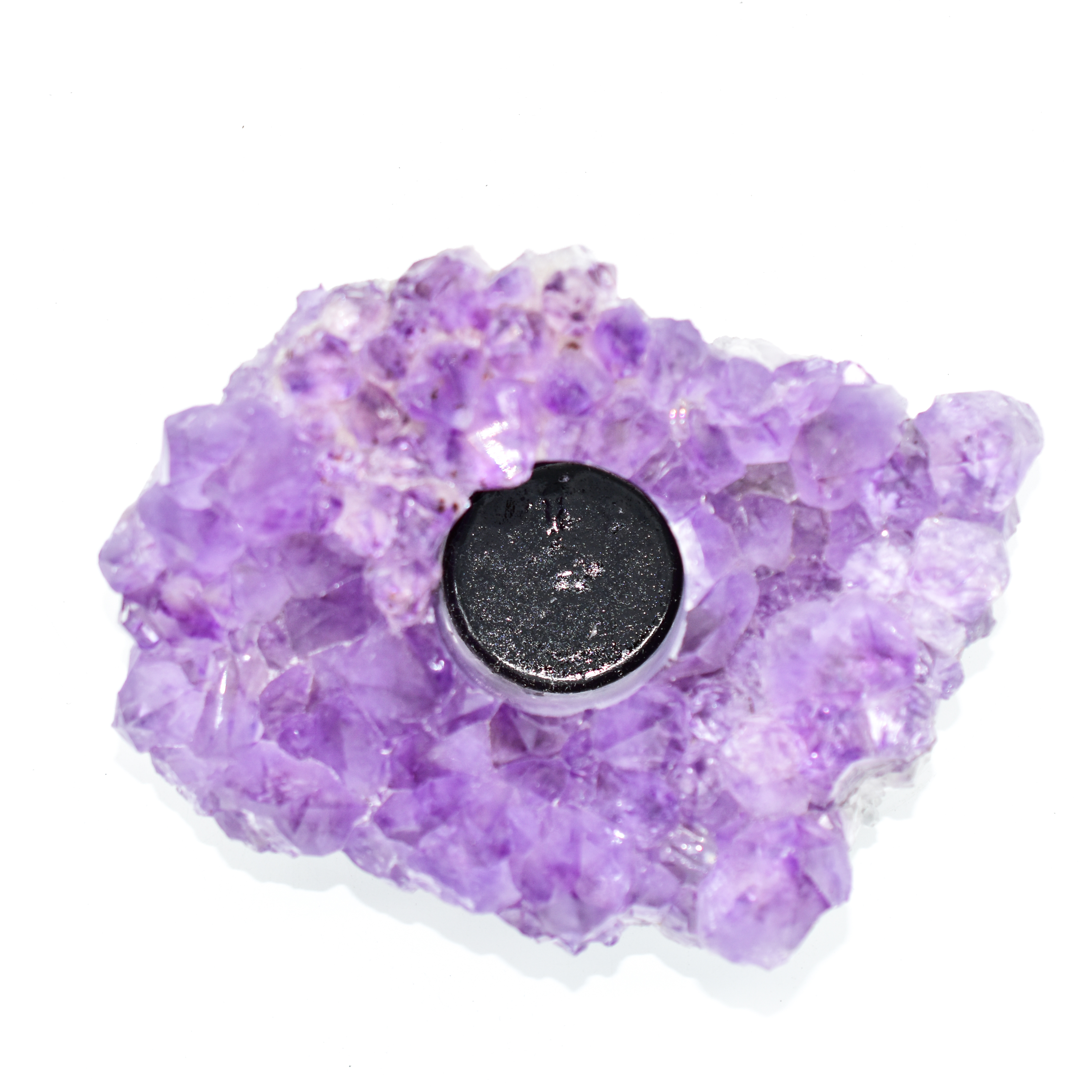 A large, natural Amethyst druzy crystal candle holder with unique colors and textures, designed for tea lights or votive candles.