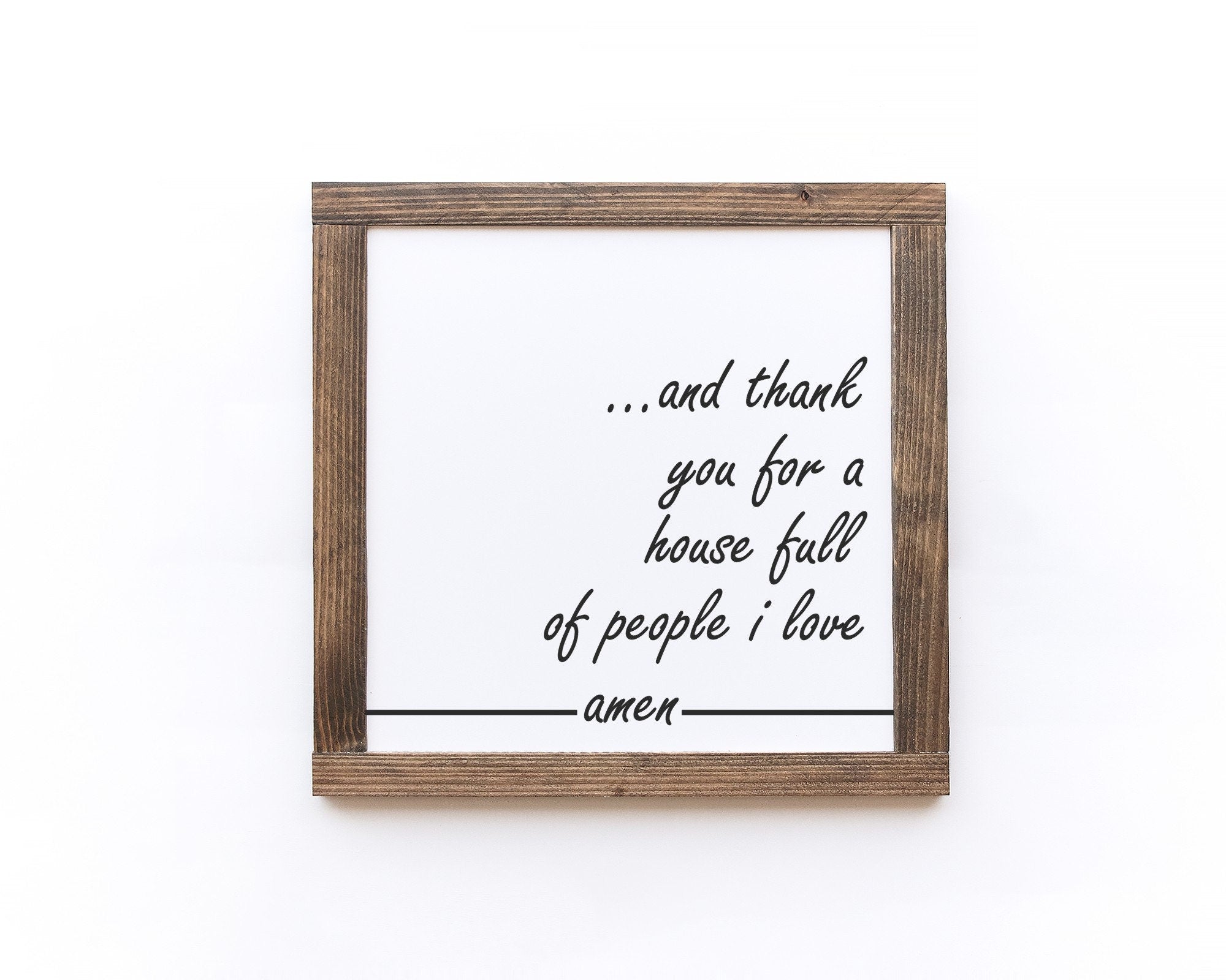 Handmade wooden sign with the phrase 'And Thank You For A House Full Of People I Love Amen' in elegant lettering on a matte white background.