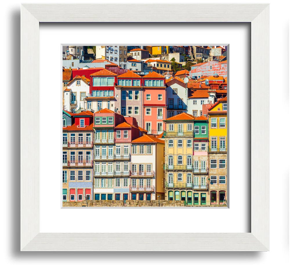 A beautifully framed print of coastal apartments, showcasing vibrant colors and intricate details, ready to hang on the wall.