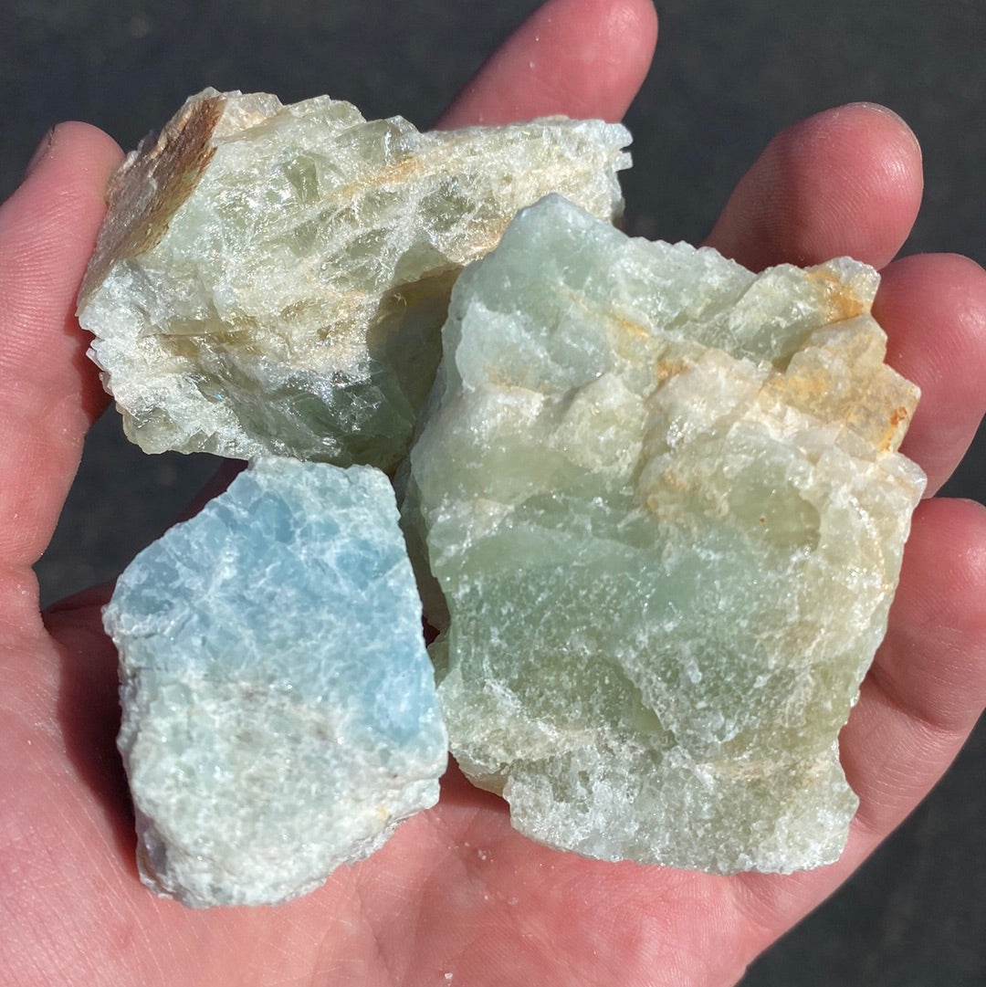 A stunning raw Aquamarine Rough Cut L crystal showcasing its natural blue and green-blue hues, perfect for crystal healing and meditation.