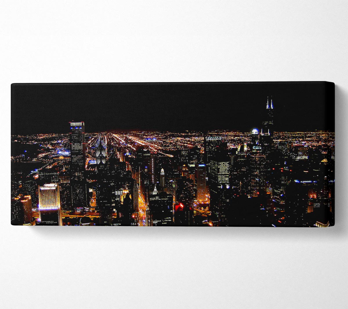 Ariel view of a vibrant city at night, showcasing illuminated buildings and streets, printed on canvas.