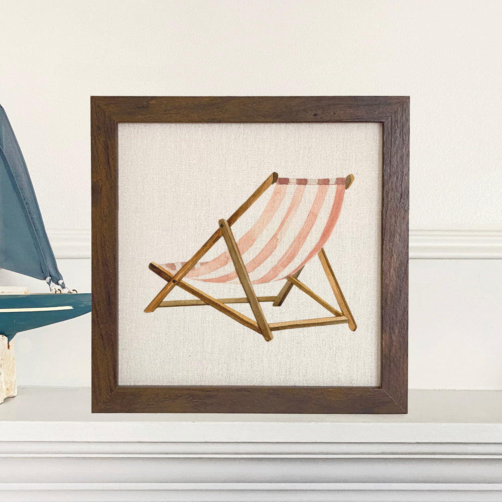 A stylish Beach Chair Framed Sign with a wood frame, featuring a linen-look background and eco-friendly printing, available in walnut and white-washed finishes.