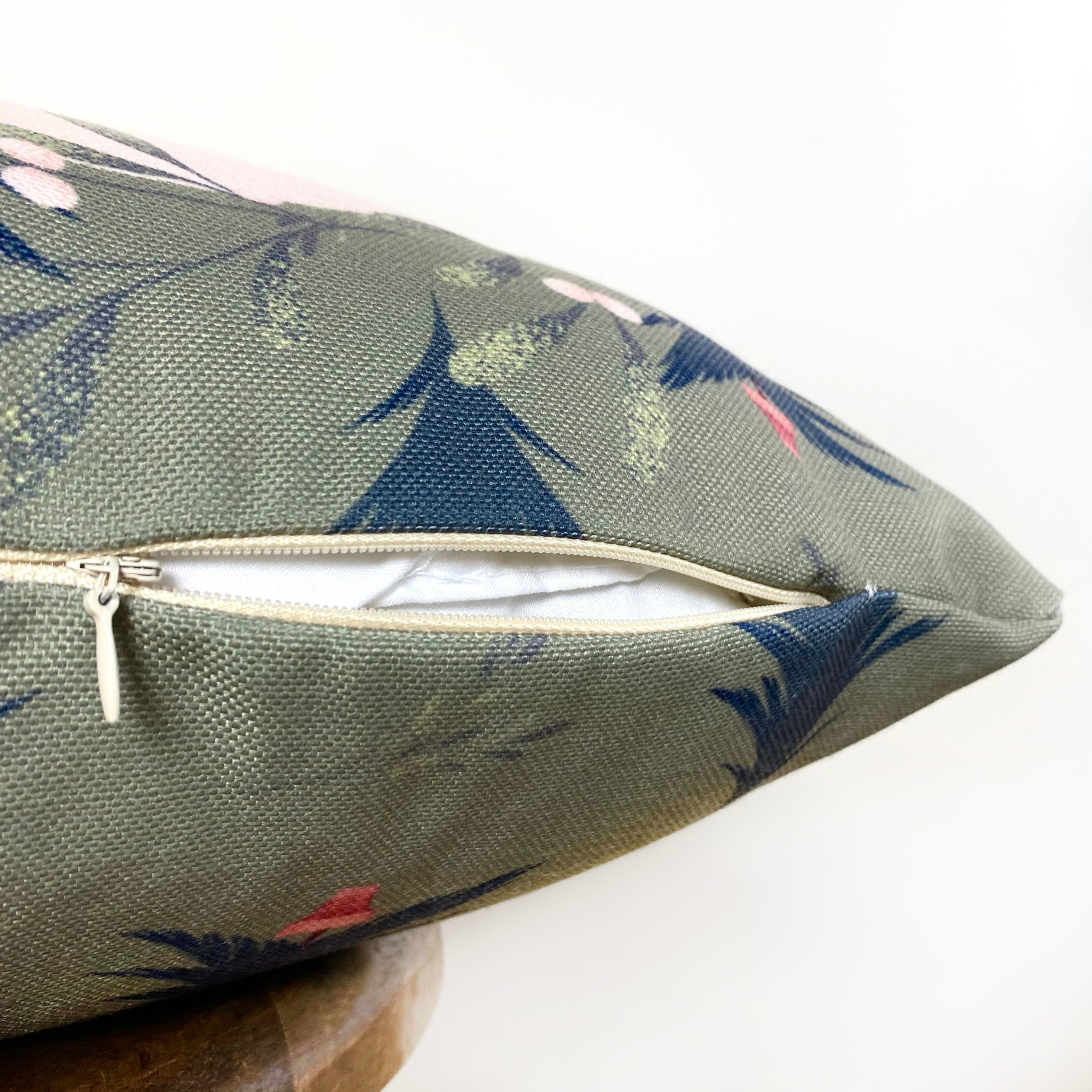 Beige Merry Christmas Throw Pillow Cover featuring a white circle with 'Merry Christmas' text, green wreath, and blue trees on a gray-green background.