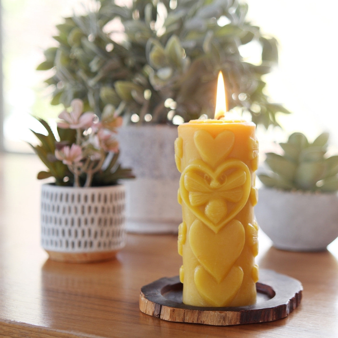 Big Dipper Wax Works Bee-Love Pillar candle, hand sculpted with a bee-in-heart design, made from 100% pure beeswax.