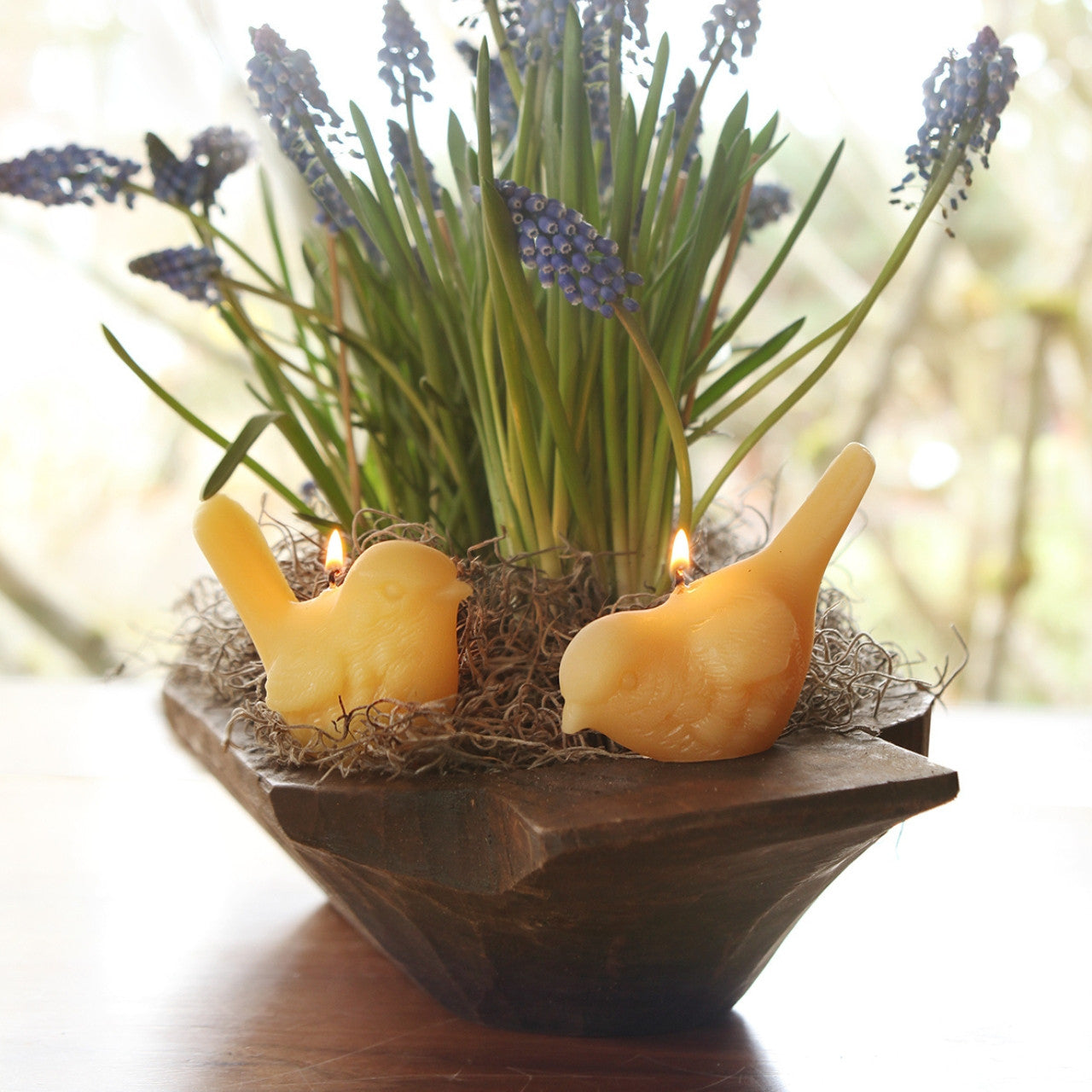 Two handcrafted beeswax song bird candles in upright and pecking positions, showcasing intricate details and natural color.