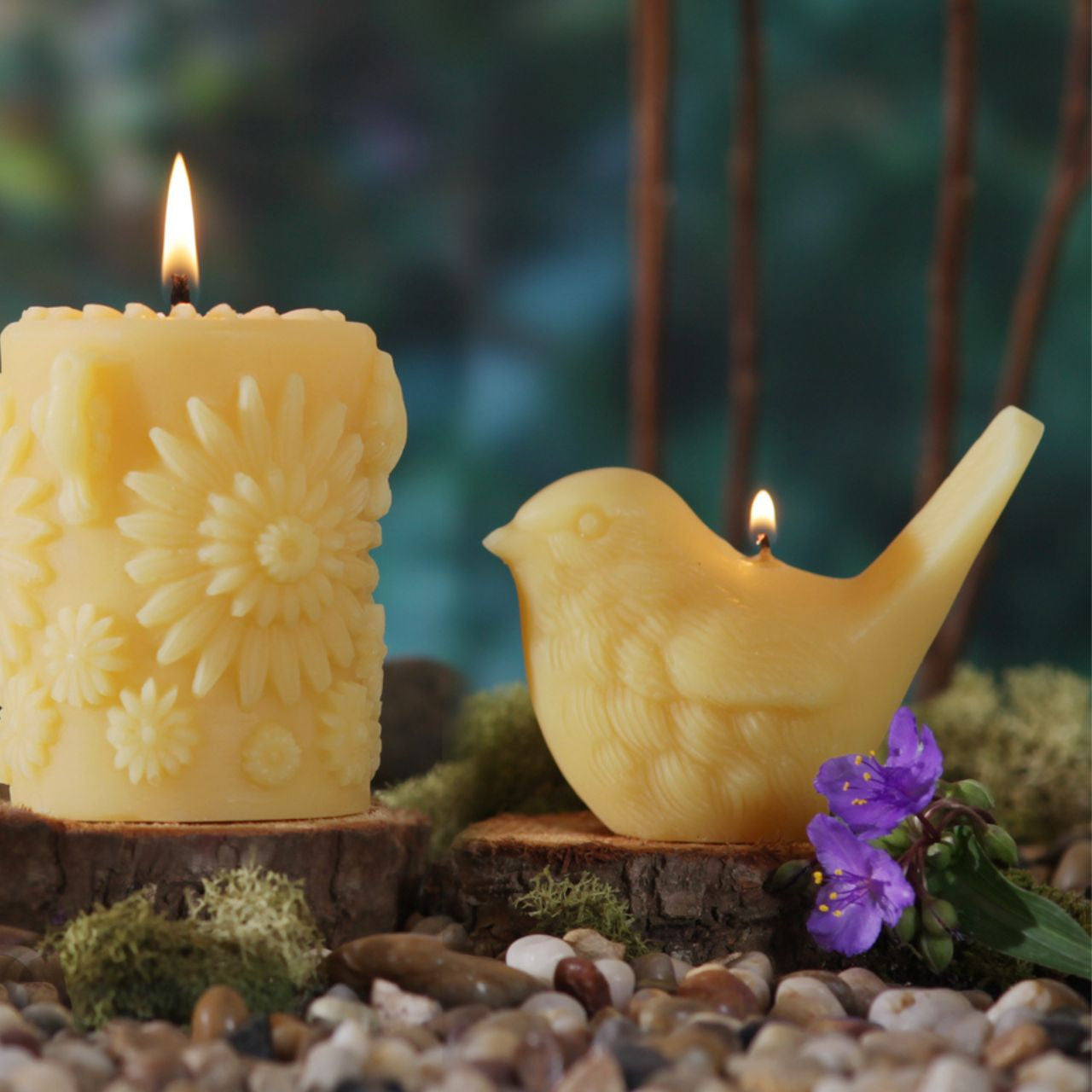 Two handcrafted beeswax song bird candles in upright and pecking positions, showcasing intricate details and natural color.