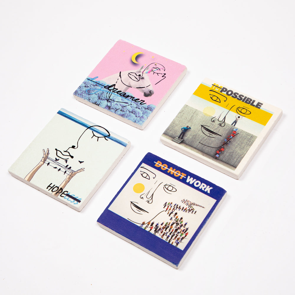 Set von vier Biggdesign Faces Natursteinuntersetzern aus Kalkstein mit bunten Designs und Korkbasis.