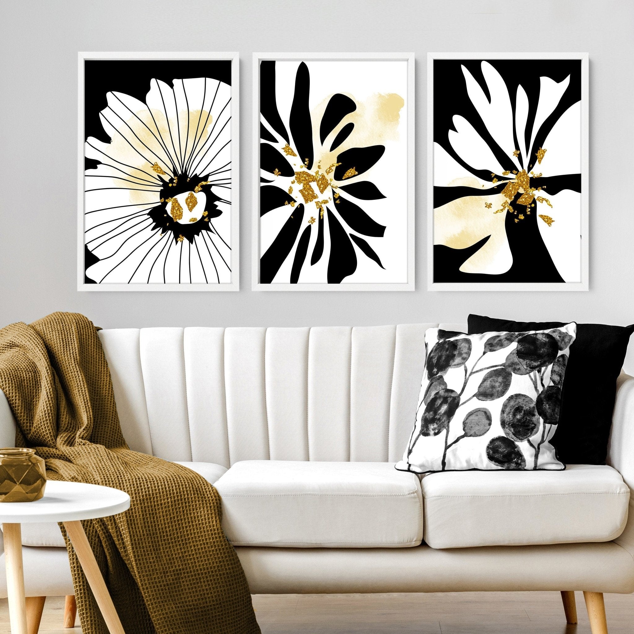 Set of 3 framed black and white botanical prints with gold shimmer details, elegantly displayed on a wall.