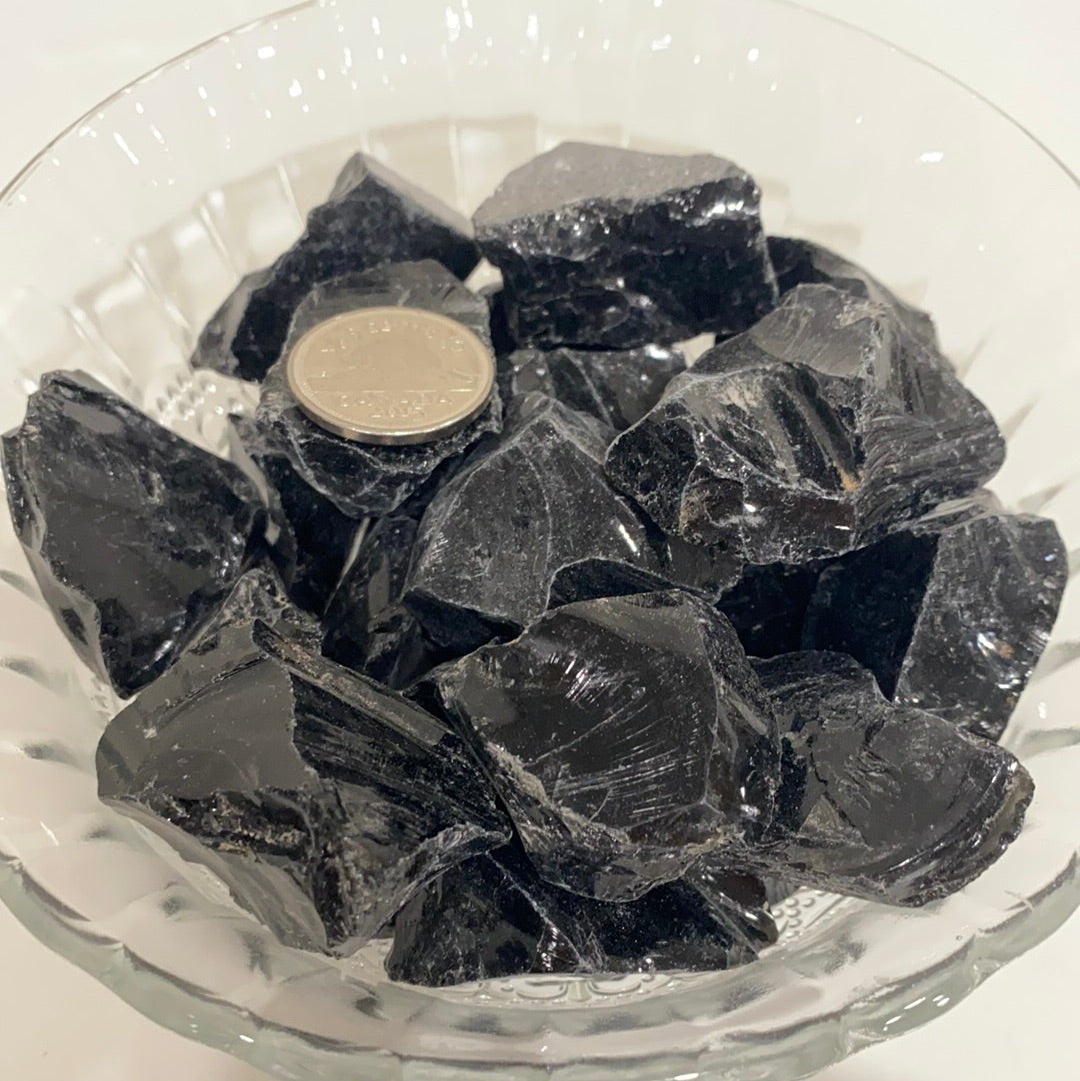 A rough cut piece of Black Obsidian showcasing its glossy black surface and natural edges, symbolizing spiritual protection and emotional healing.