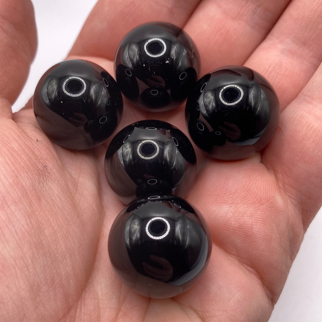 A polished 20mm Black Onyx Sphere with a glossy black finish, symbolizing strength and protection.