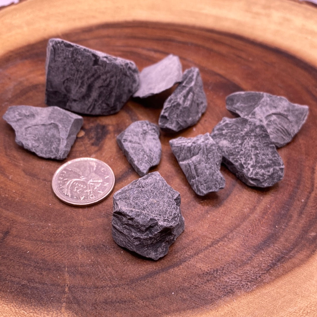 A raw Black Onyx Rough Cut crystal with a glossy black surface, showcasing its unique hexagonal shapes and natural beauty.