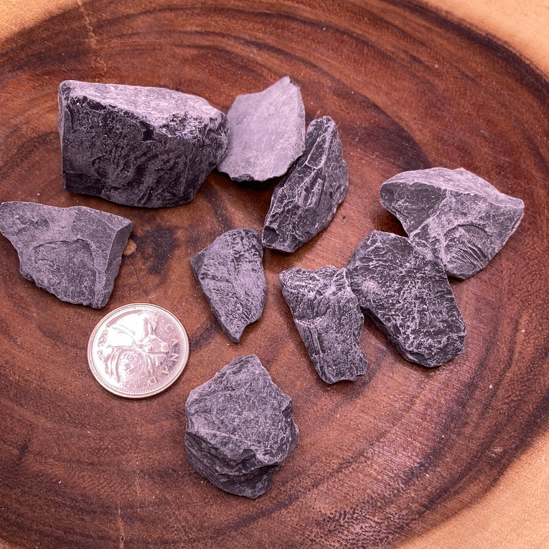 A raw Black Onyx Rough Cut crystal with a glossy black surface, showcasing its unique hexagonal shapes and natural beauty.