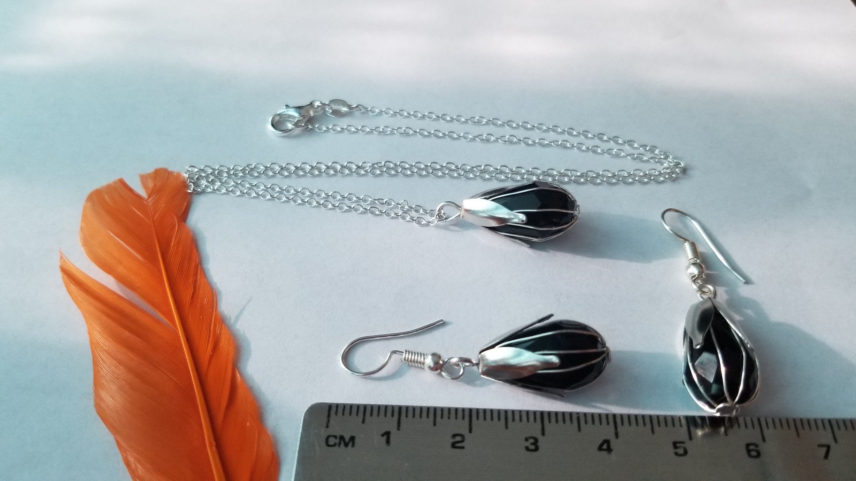 Elegant black pendant with chain and matching earrings, showcasing a translucent design.