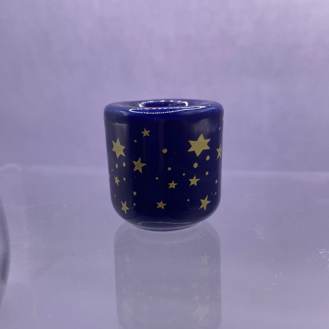 A beautiful blue porcelain candle holder adorned with gold stars, designed to fit a 1/2 inch candle, perfect for candle magic.