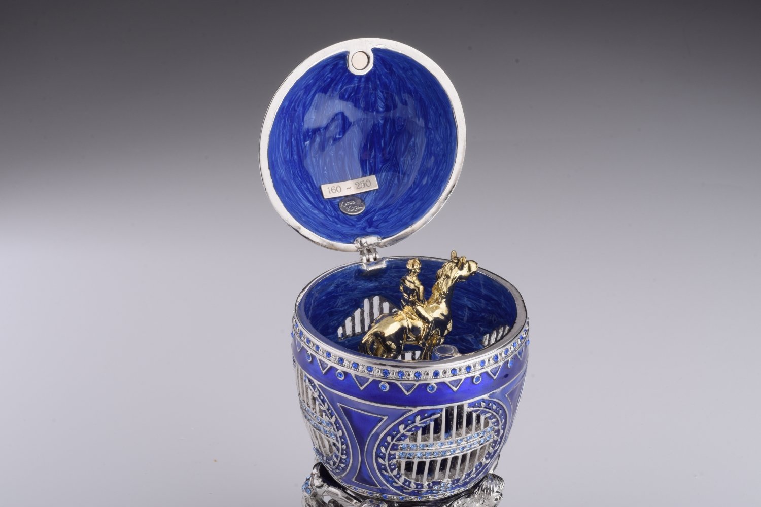 A beautifully crafted Blue Russian Egg trinket box featuring a man riding a horse, adorned with Austrian crystals and 24K gold plating.