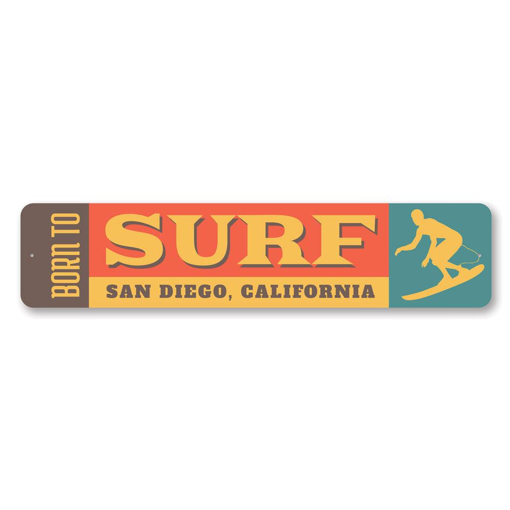 A decorative 'Born to Surf' sign made of durable aluminum, featuring vibrant colors and a beach-themed design, perfect for surf enthusiasts.