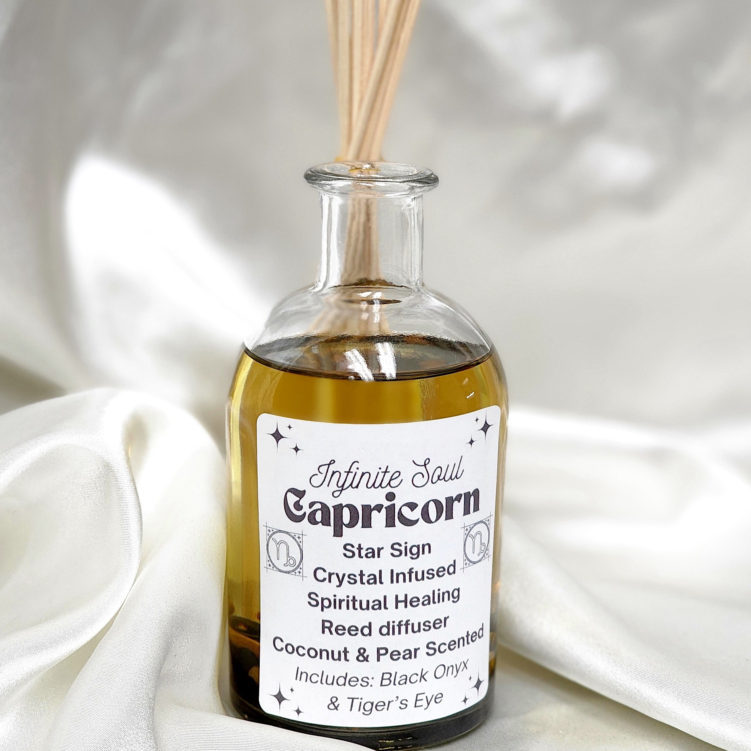 Capricorn Star Sign Crystal Infused Reed Diffuser with Coconut & Pear scent, featuring Black Onyx and Tiger's Eye crystals in a stylish bottle.