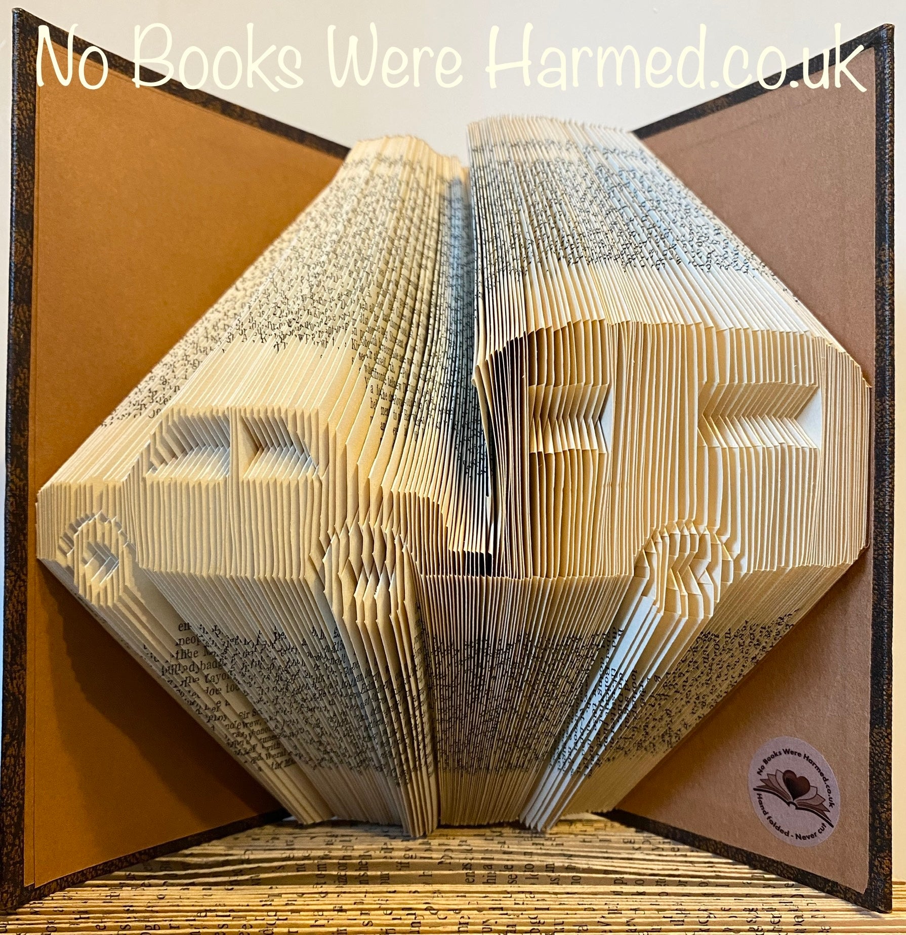 Hand folded book art featuring a Car & Caravan design, showcasing intricate folds and unique colors from vintage books.
