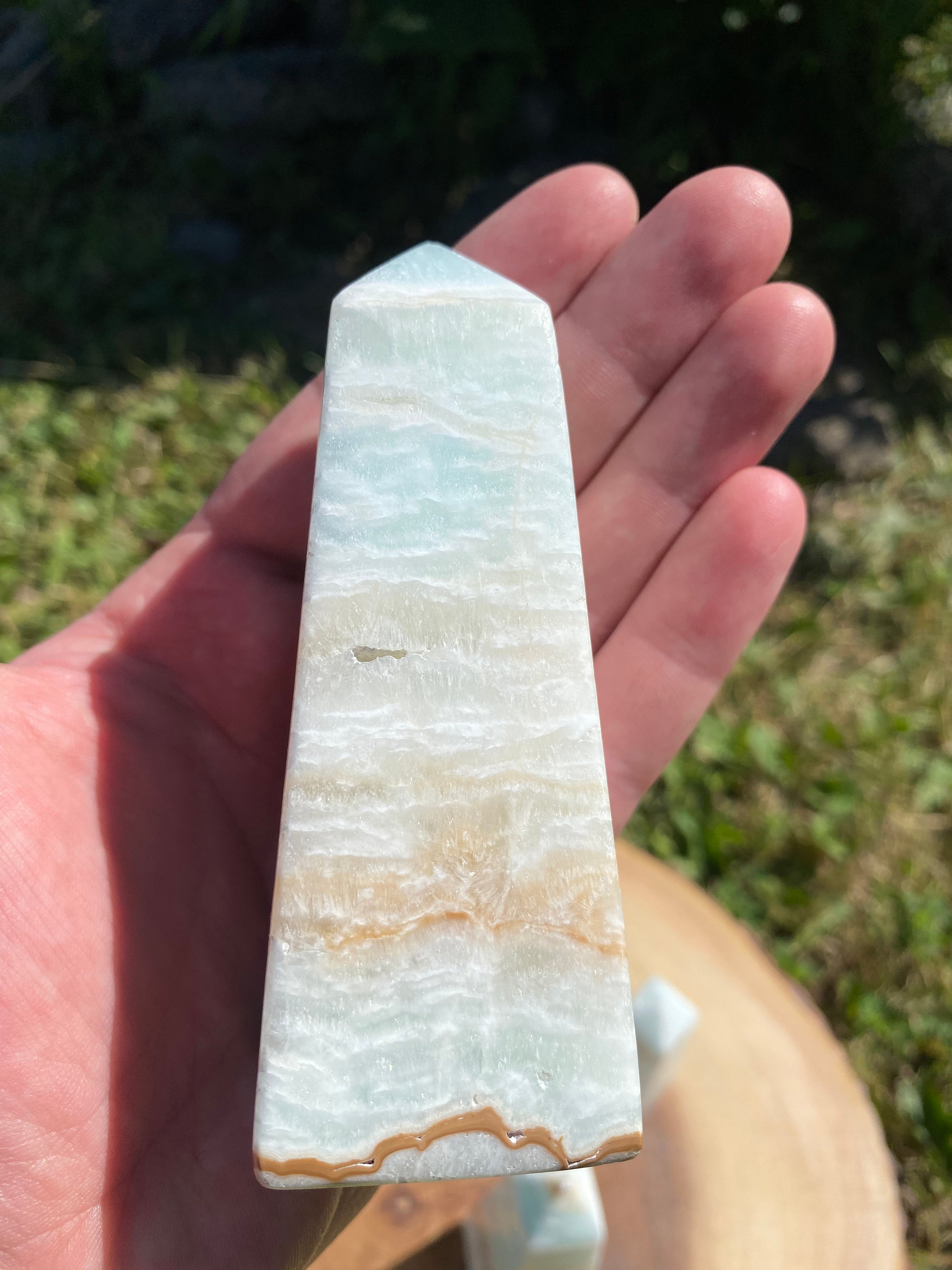 A beautifully crafted Caribbean Calcite Obelisk showcasing vibrant blue, green, and yellow colors, symbolizing tranquility and positive energy.