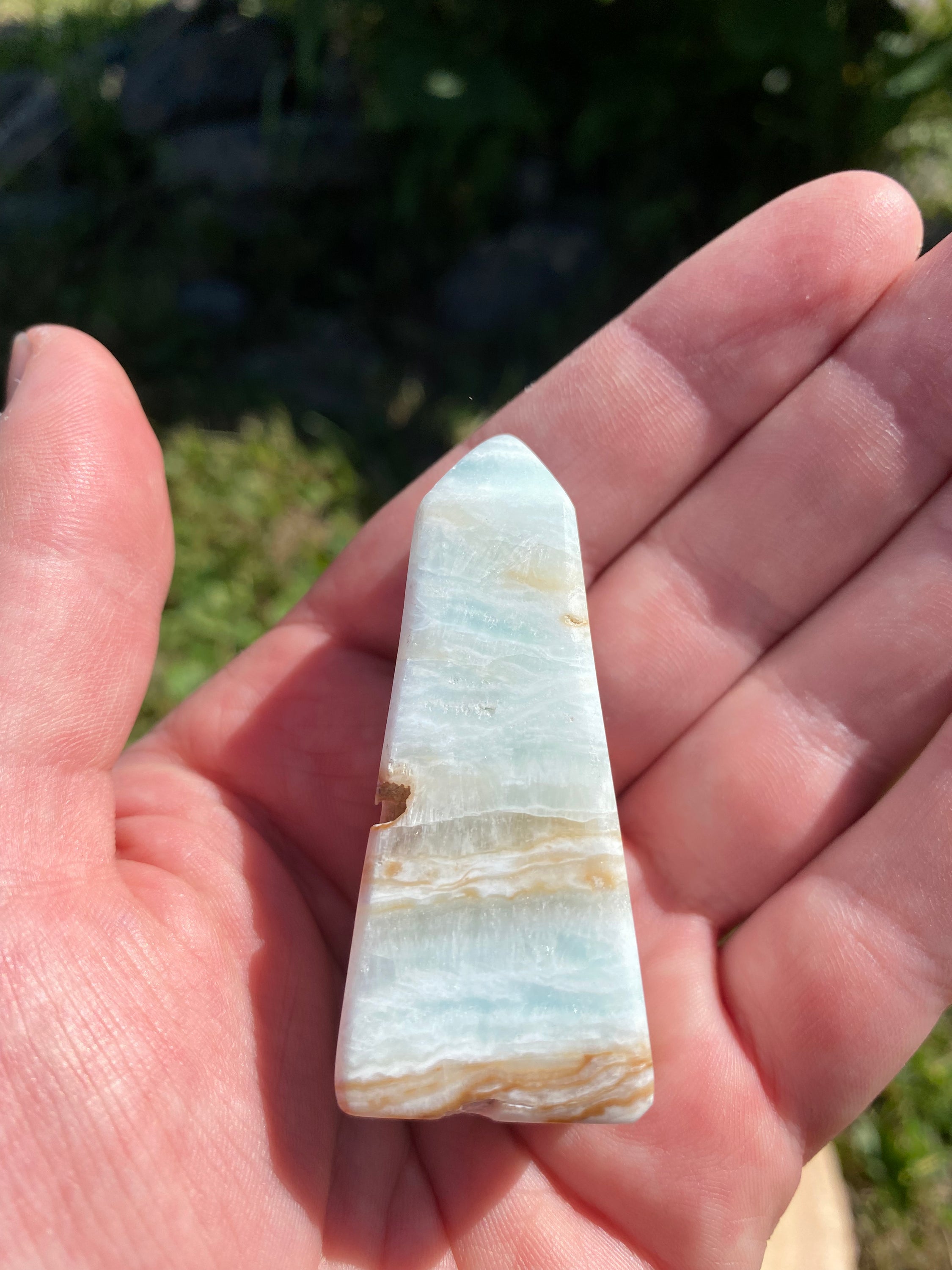 A beautifully crafted Caribbean Calcite Obelisk showcasing vibrant blue, green, and yellow colors, symbolizing tranquility and positive energy.