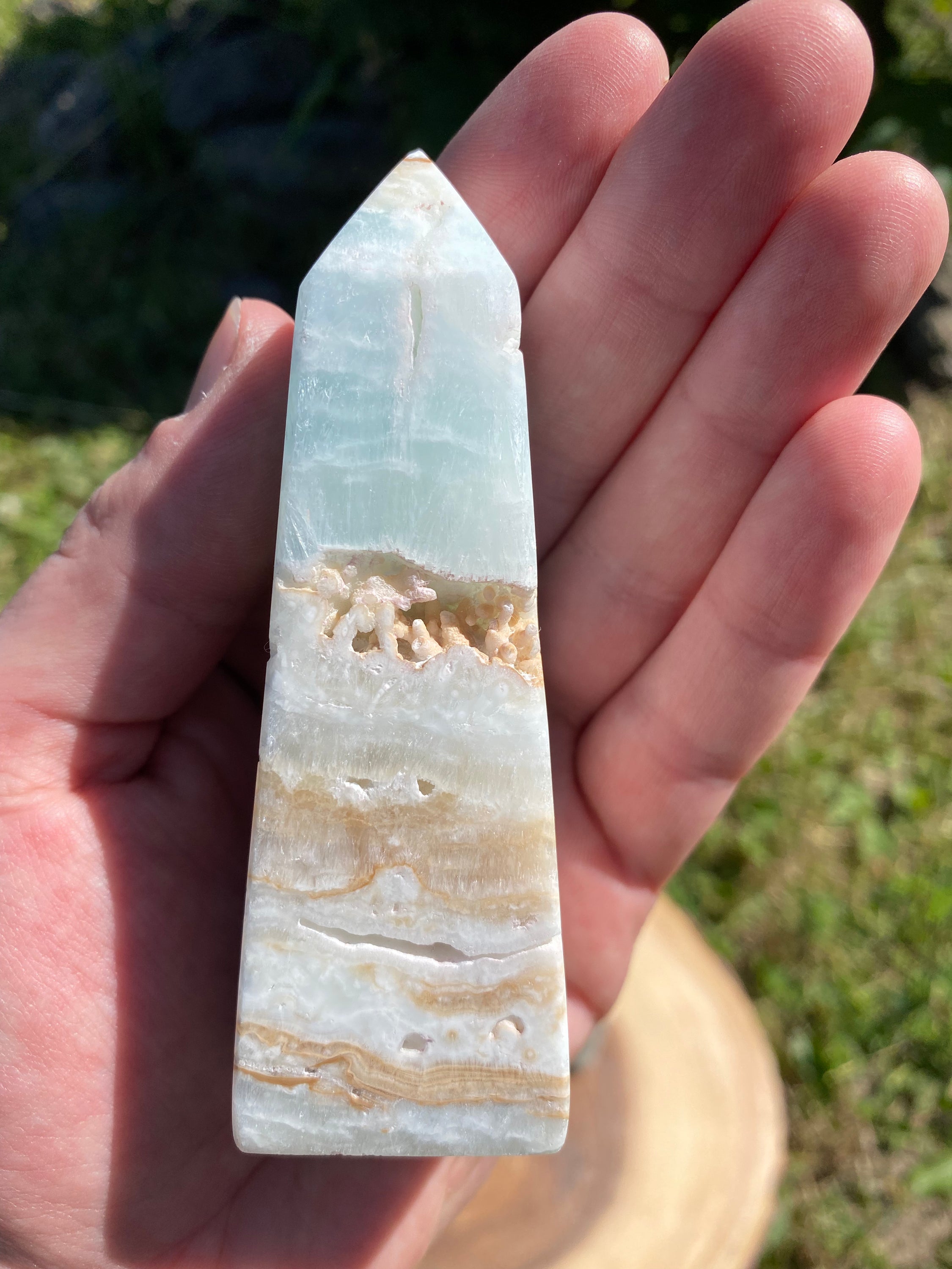 A beautifully crafted Caribbean Calcite Obelisk showcasing vibrant blue, green, and yellow colors, symbolizing tranquility and positive energy.