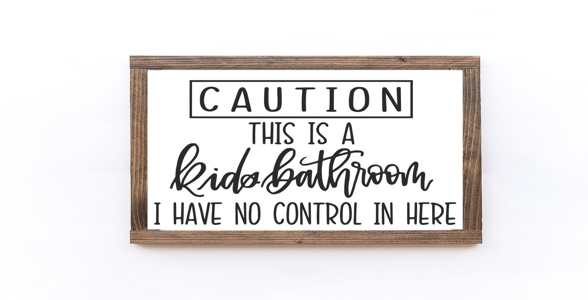 Caution This Is A Kids Bathroom Wood Sign with white background and black lettering, showcasing its handmade quality and unique wood grain.