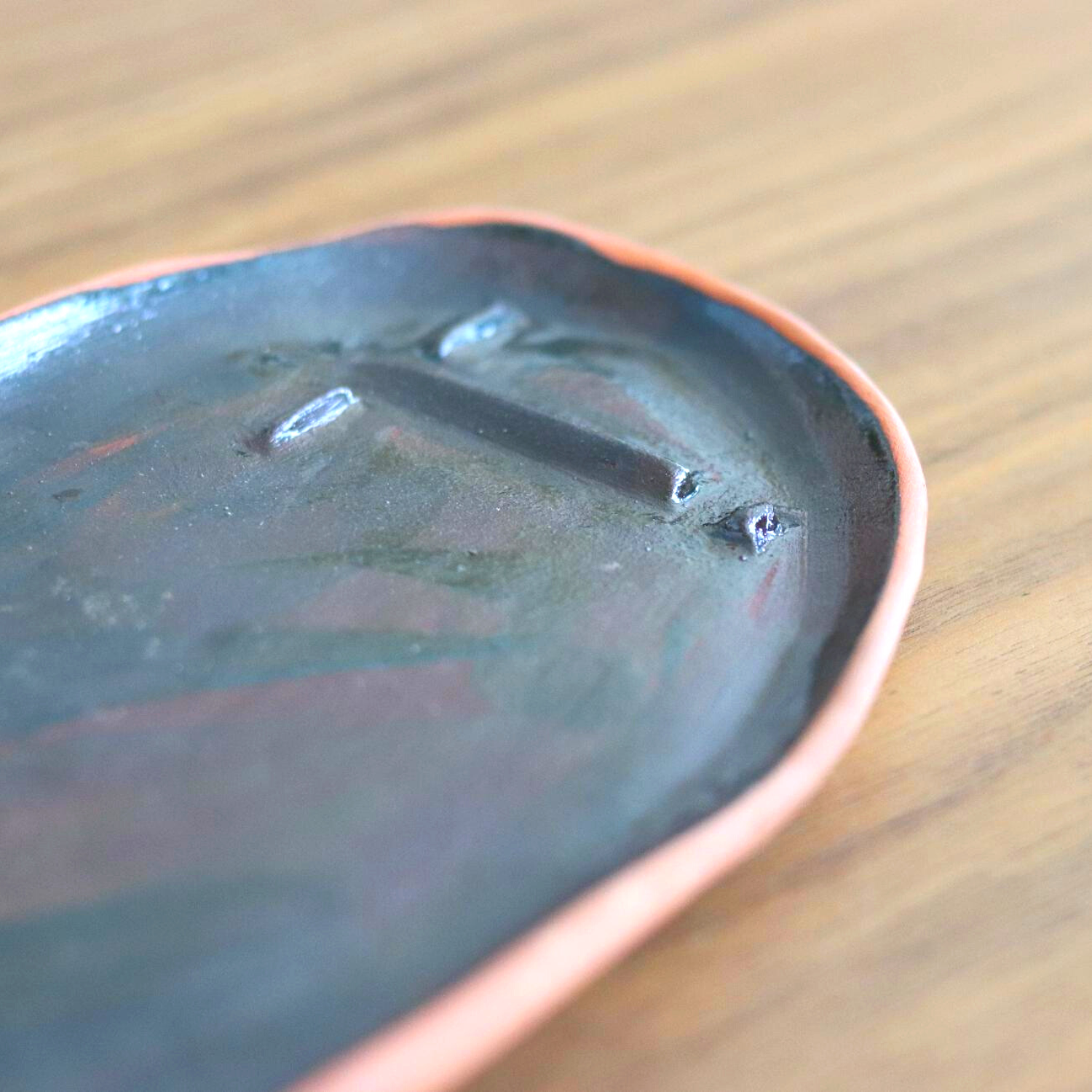 Ceramic Handmade Decorative Tray featuring intricate face details in a deep navy speckled finish, showcasing artisan craftsmanship.