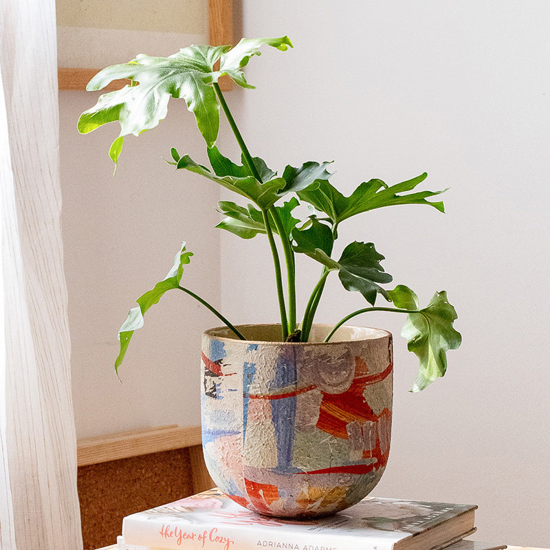 A medium-sized ceramic planter with a stylish design, perfect for home gardening, featuring a smooth finish and ideal dimensions for indoor plants.