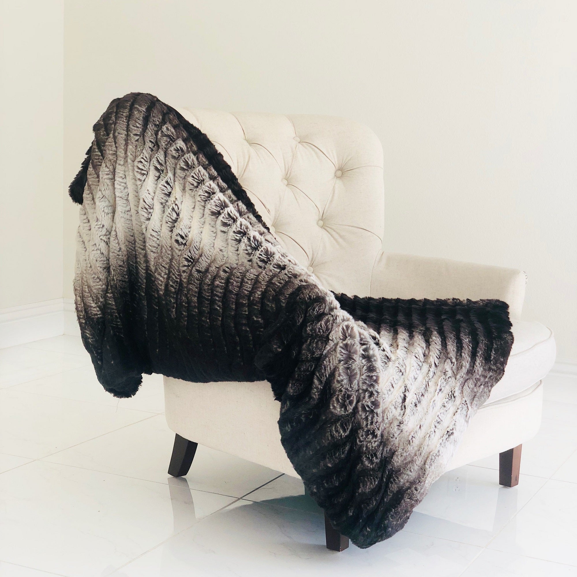 Luxurious chocolate brown faux fur throw blanket with soft microfiber backing, elegantly draped over a cozy couch.