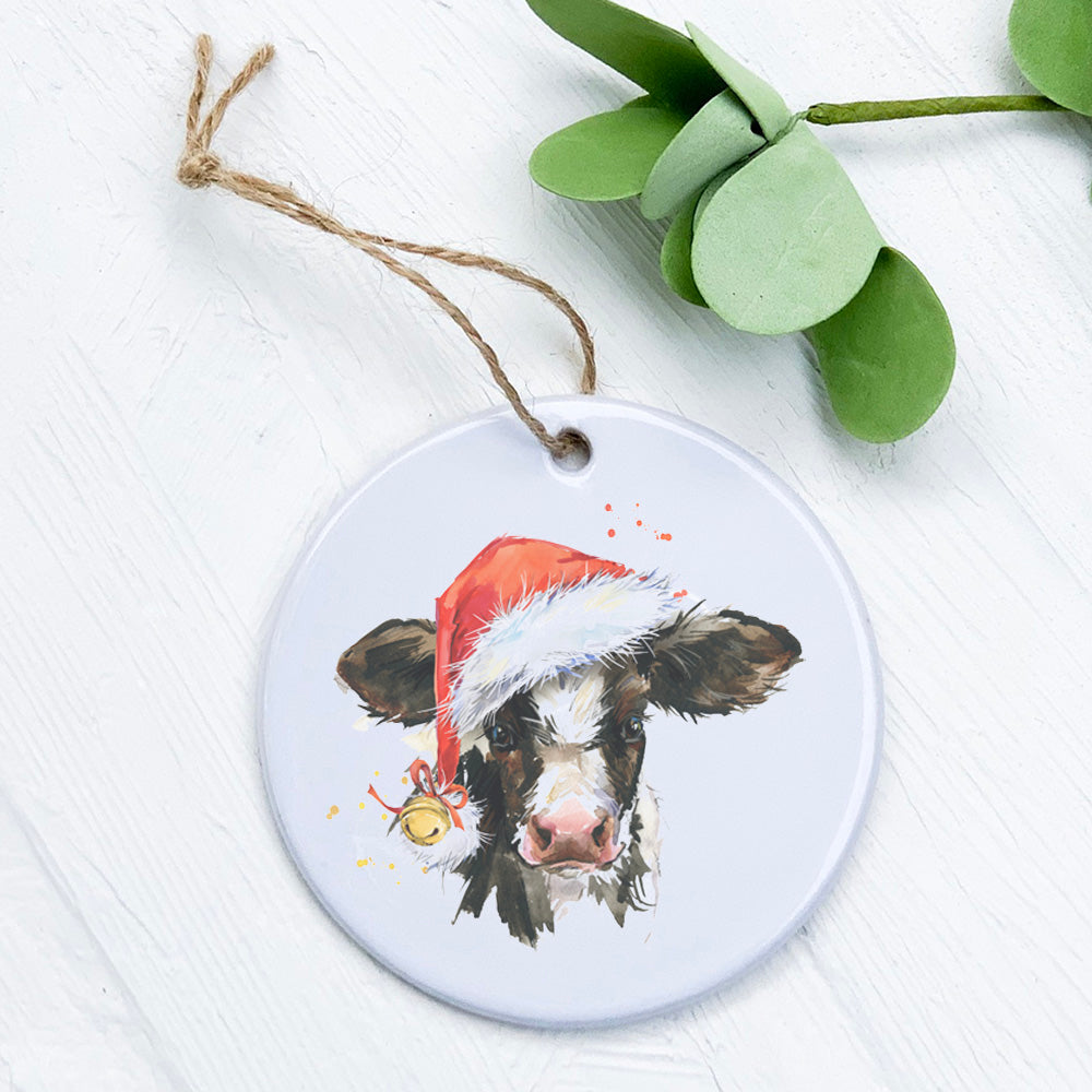 A beautifully crafted porcelain Christmas Cow ornament featuring vibrant colors and a glossy finish, perfect for holiday decor.