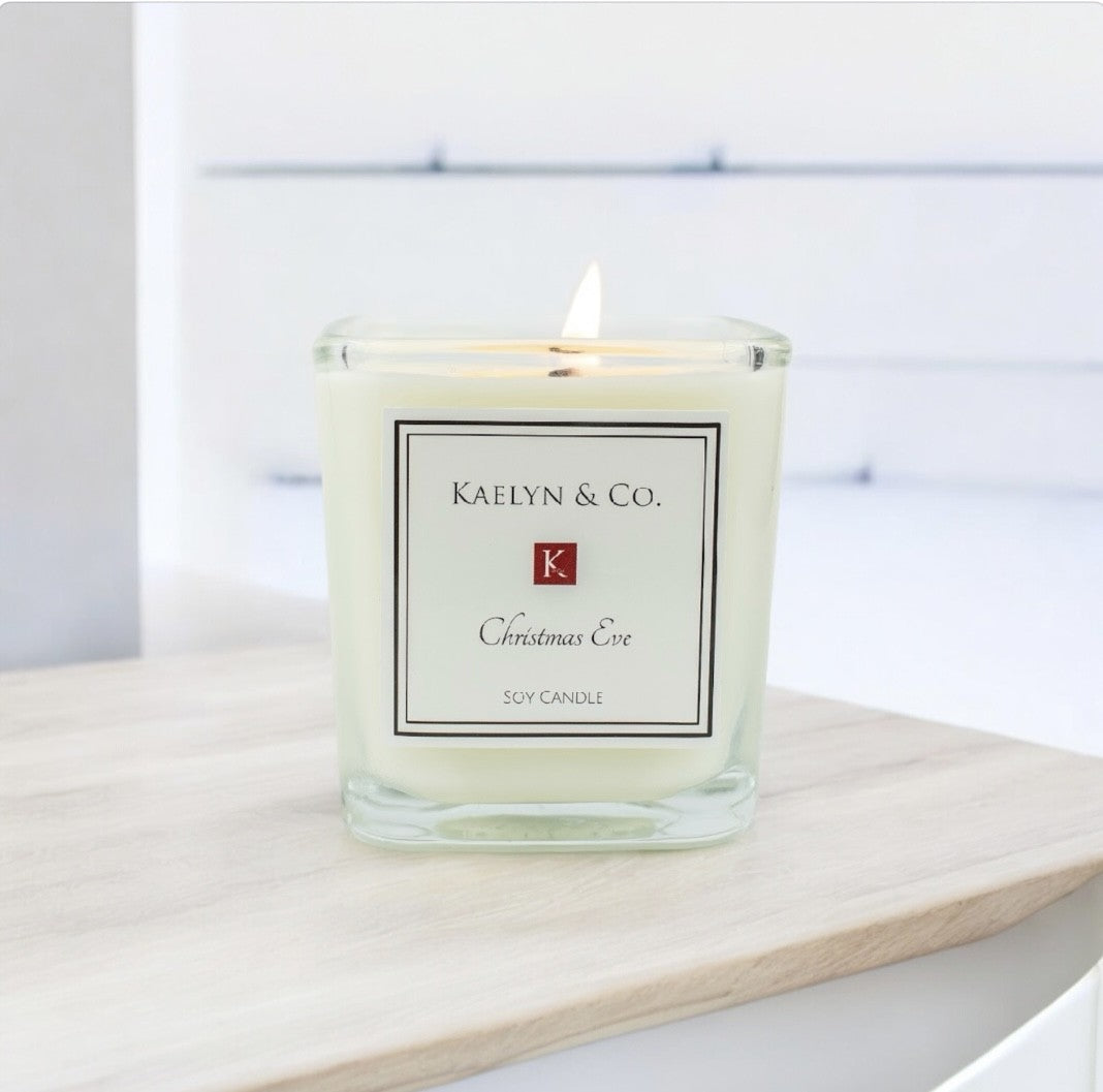 A beautifully crafted Christmas Eve Small Cube Candle with a festive design, showcasing its warm orange spice, fir, and pine fragrance.