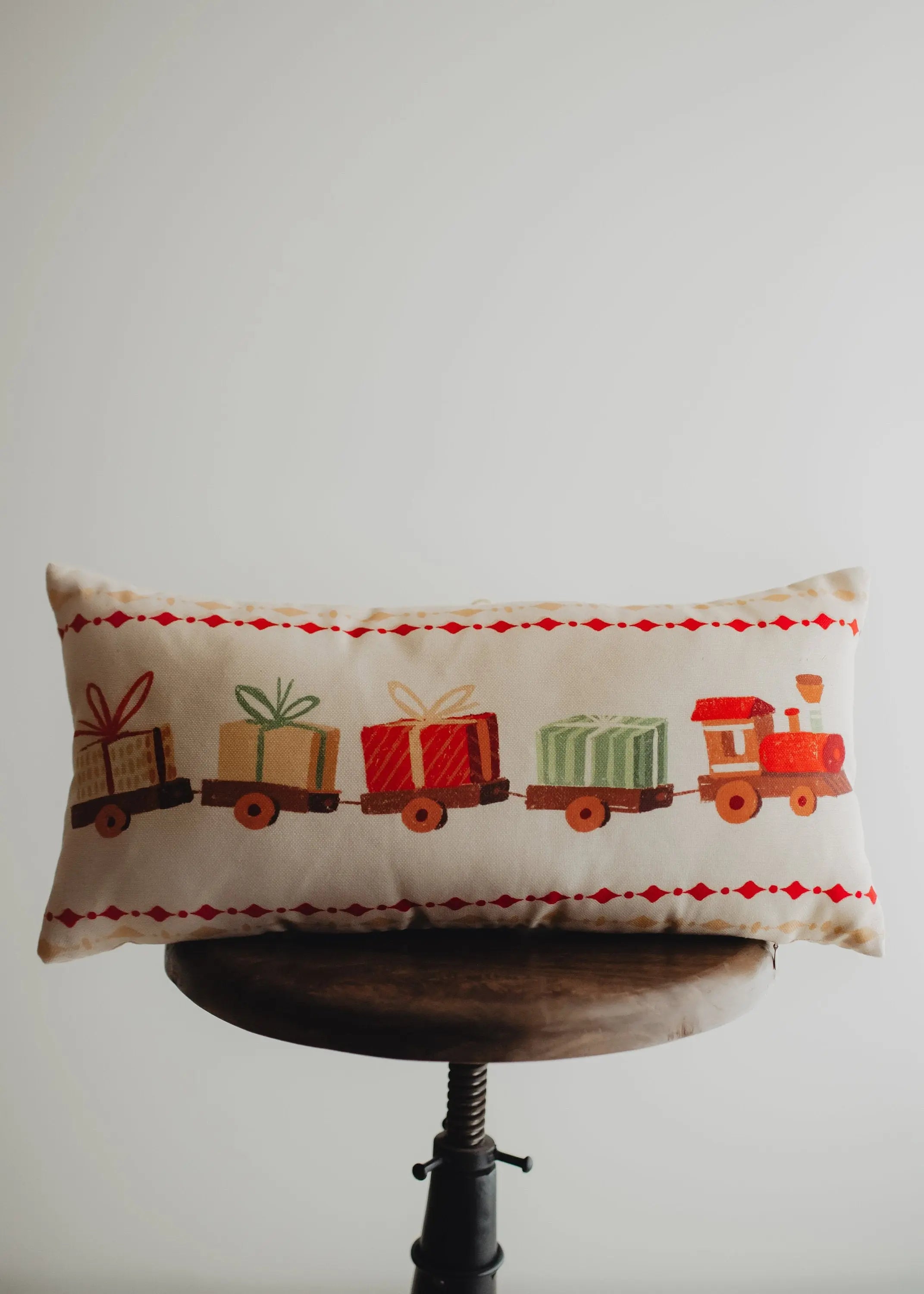 Christmas Gift Train throw pillow cover featuring a toy train carrying wrapped presents on a cream background, perfect for holiday decor.