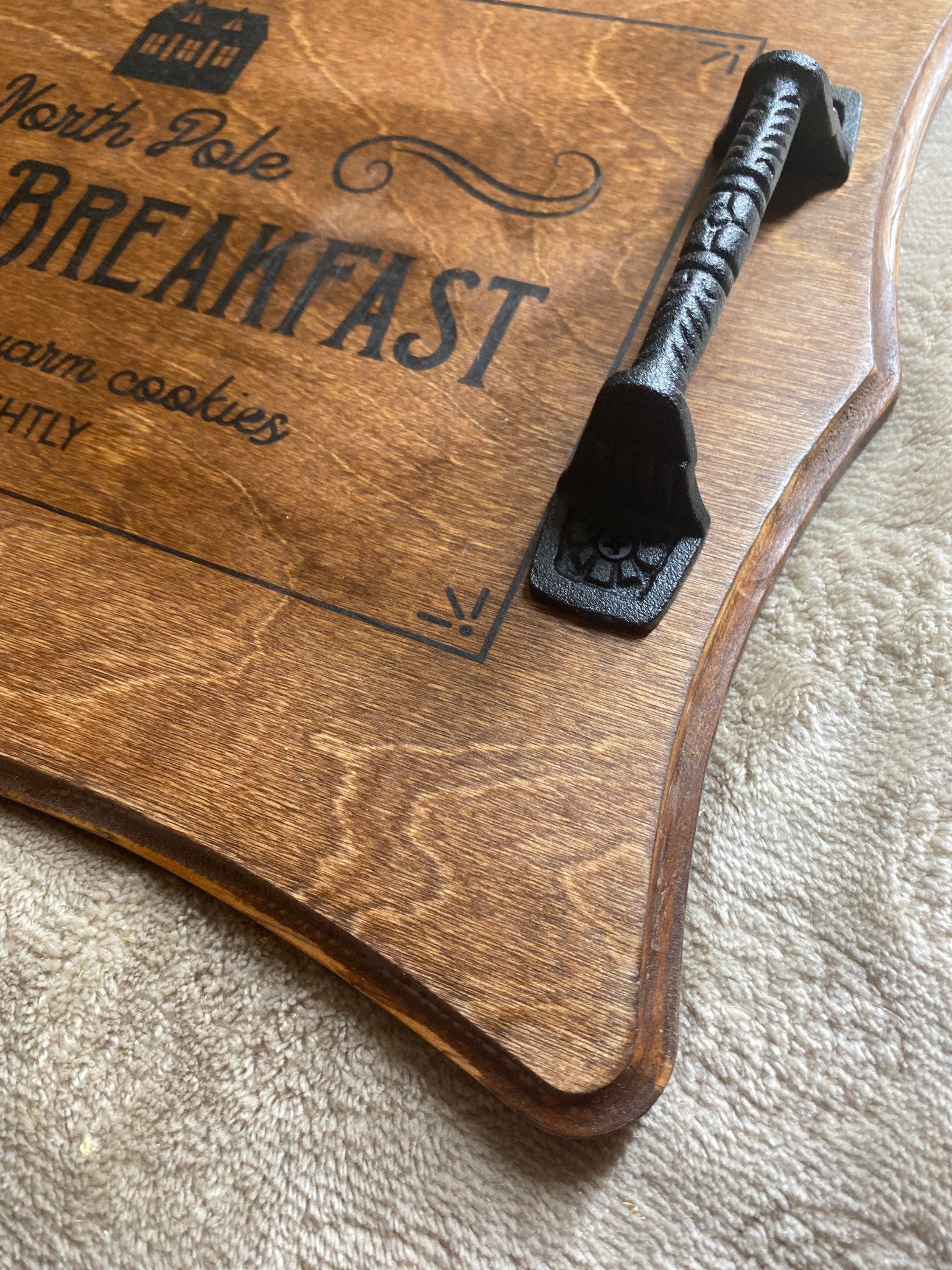 Handmade Christmas serving tray made of birch plywood with a rich chestnut stain, featuring black metal handles and unique wood grain patterns.