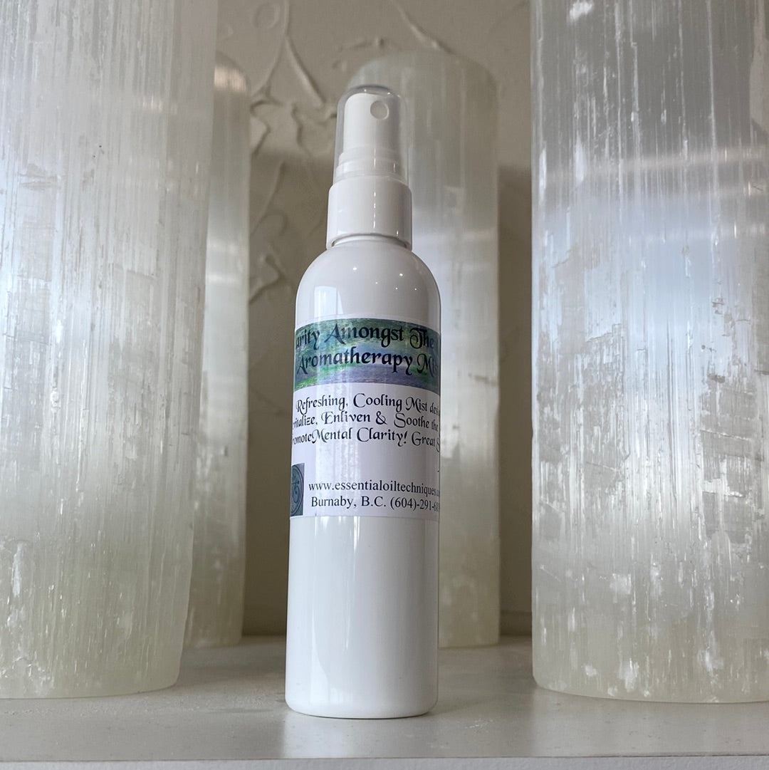 Clarity Amongst the Chaos Aromatherapy Mister with a refreshing mist, surrounded by crystals and natural elements.