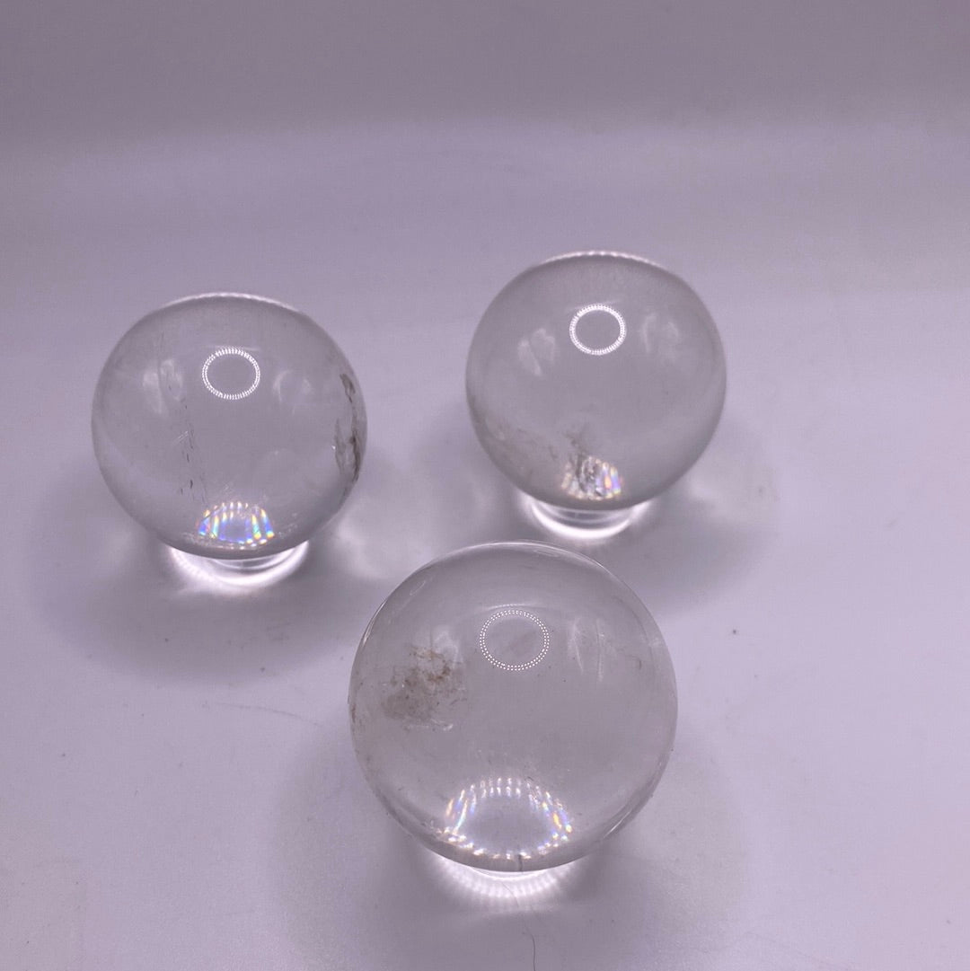 A beautiful Clear Quartz Sphere, approximately 35-40mm in size, showcasing its translucent and opaque qualities.