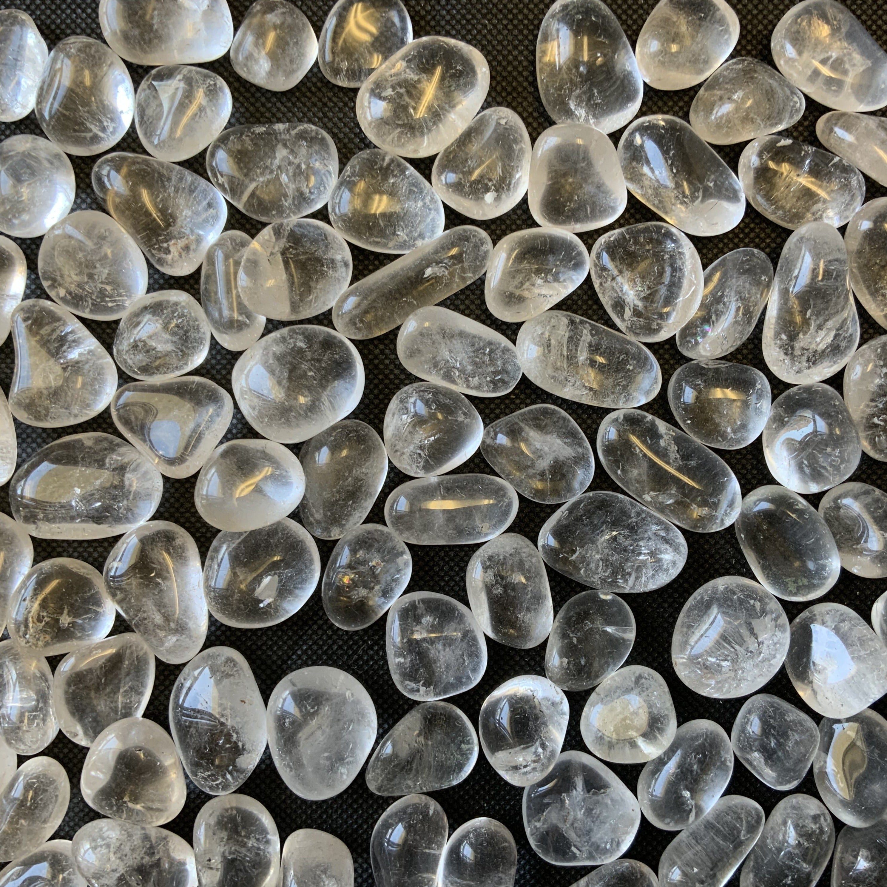 A collection of Clear Quartz Tumbled Crystal Stones, showcasing their unique shapes and smooth surfaces, perfect for healing and meditation.