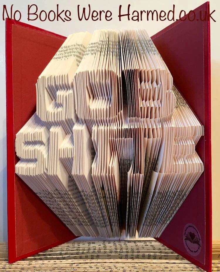A collection of unique hand-folded book art pieces made from vintage books, showcasing intricate designs and various colors.