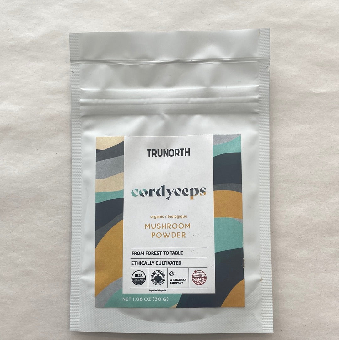 A bag of Cordyceps Organic Mushroom Powder with a scoop, showcasing its fine texture and earthy color.