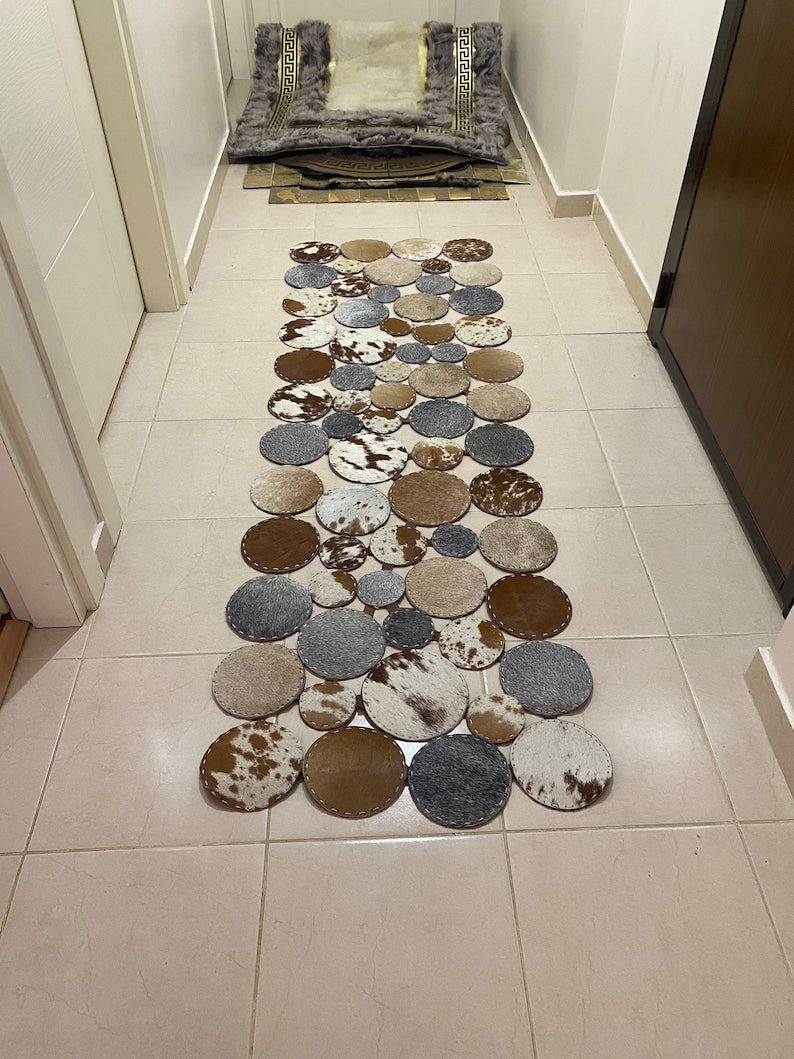 A luxurious round patchwork cow skin rug showcasing natural leather textures and patterns, perfect for modern home decor.