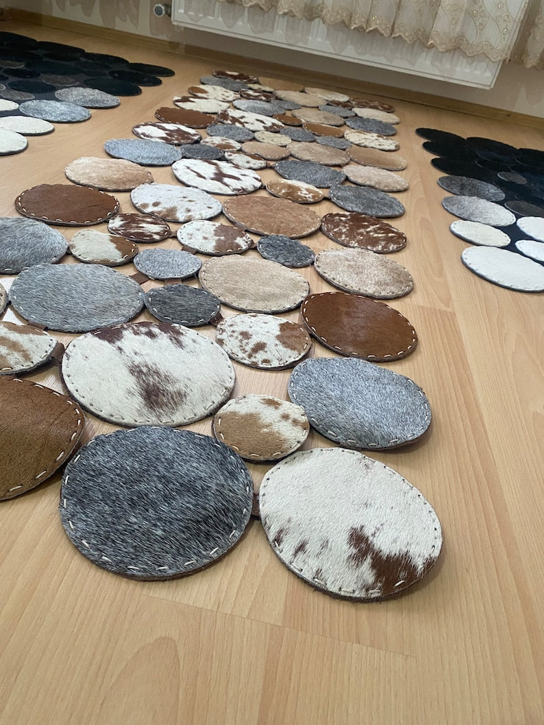 A luxurious round patchwork cow skin rug showcasing natural leather textures and patterns, perfect for modern home decor.